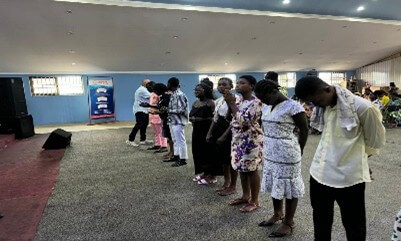A line of people standing at the front of a church, participating in a mission-related service.